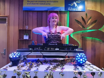 A person with disability behind a DJ set up.