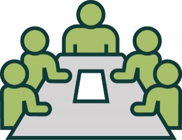 A group of people working together at a table. On the table is a document.