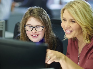 A person with disability being trained to do work on a computer.