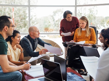 A group of people having a meeting about a document. 